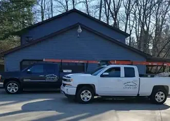 Madison County Roofing trucks on a residential job site